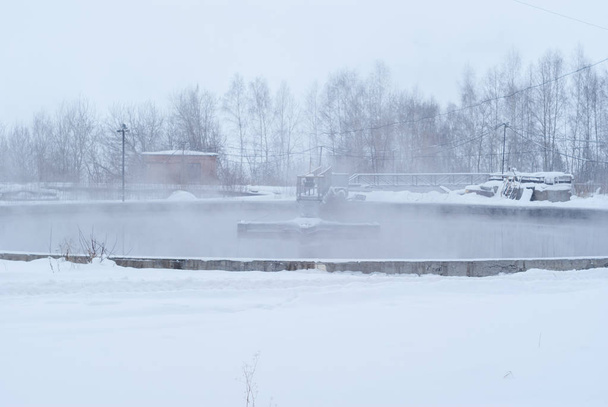 estação de tratamento de esgoto no inverno, tanques de decantação primários gelados
 - Foto, Imagem
