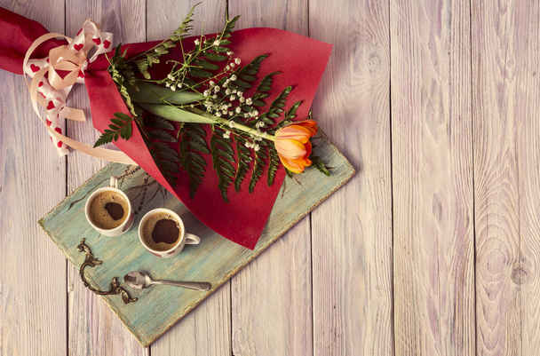 Композиция на День Святого Валентина или день рождения. Романтический букет тюльпанов и чашка кофе на деревянном столике крупным планом
. - Фото, изображение