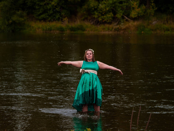 Muotokuva iloinen nuori nainen joessa pukeutunut vihreä osapuoli mekko
 - Valokuva, kuva