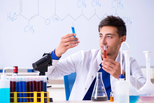 Young chemist sitting in the lab  - 写真・画像
