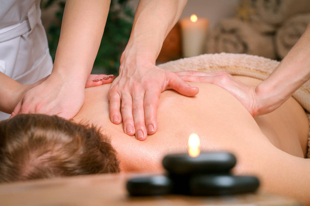 Młody człowiek, otrzymujący ramię i masaż pleców z terapeutą w spa - Zdjęcie, obraz