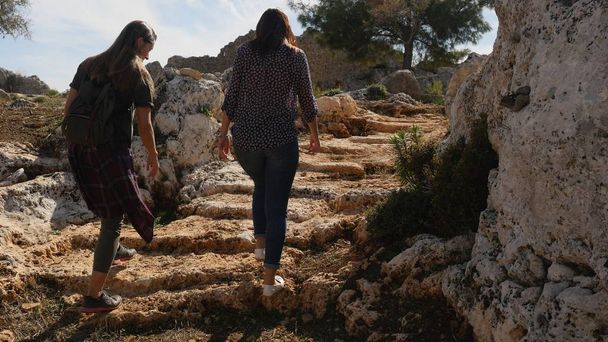 Duas jovens garotas explorando a cidade antiga Lyrboton, Turquia
 - Foto, Imagem