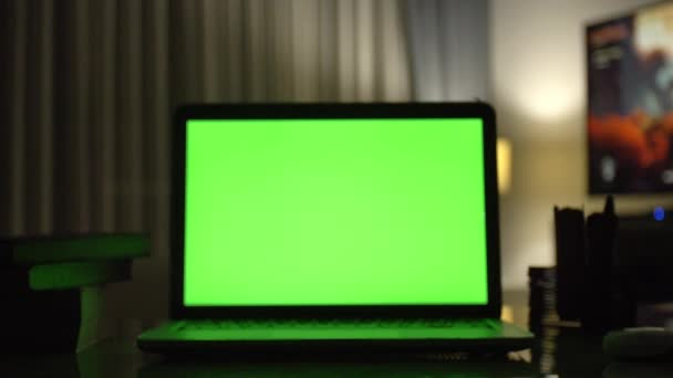 緑色の画面でノート パソコン。暗いホーム オフィス。あなた自身のイメージやビデオを配置する最適のドリー ショット.  - 映像、動画