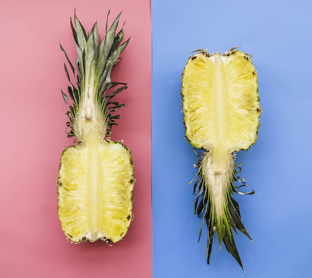 Creative layout made of pineapple on pink and blue background. Tropical flat lay. Food concept. - Photo, image