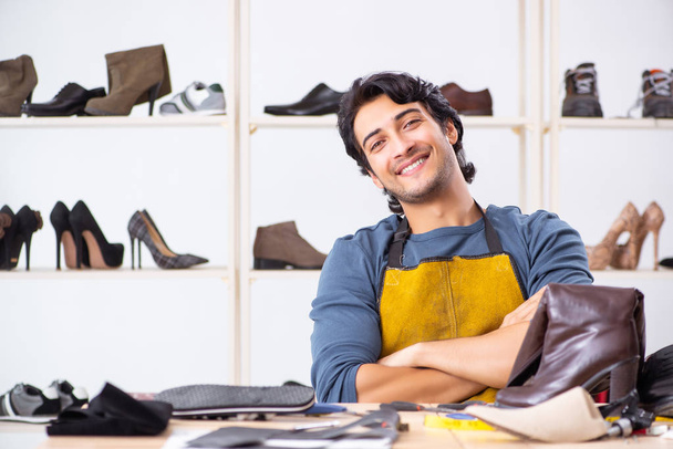 Mladý muž, oprava obuvi v dílně  - Fotografie, Obrázek