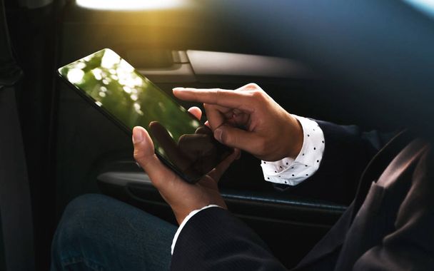 businessman working in a car and using a tablet - Foto, Bild