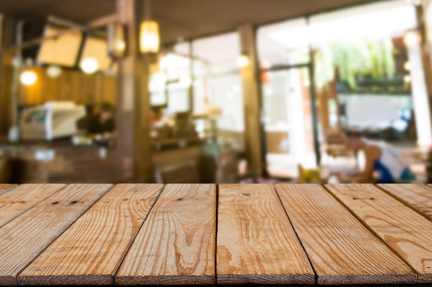 κενό ξύλινο τραπέζι μπροστά του θαμπάδα μοντάζ αφηρημένα φόντο. - Φωτογραφία, εικόνα