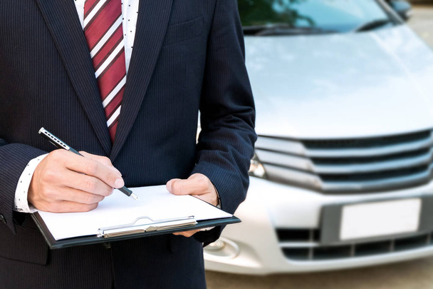 An insurance expert employee working with a car at the outdoor - Foto, imagen