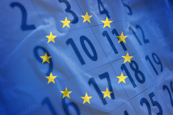 The flag of European Union with calendar of the month in the background. Full frame concept of political event date reminder - Photo, Image
