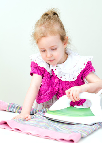Cute little girl ironing clothes - Foto, imagen