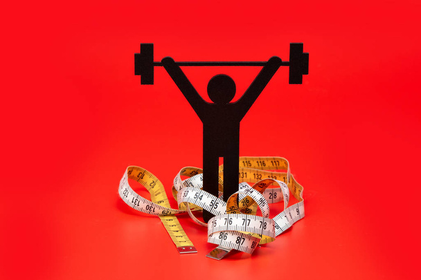 weight lifting pictogram, tape measure and red background - Photo, Image