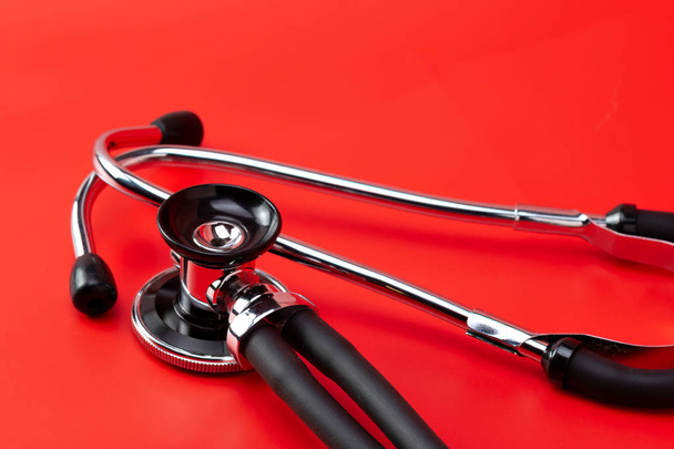 Stethoscope, medical instrument, close-up isolated with red background - Photo, Image