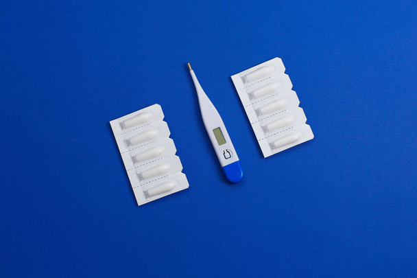 Медицинский суппозиторий для анального или вагинального применения и термометра. Свечи для обработки при высокой температуре
 - Фото, изображение