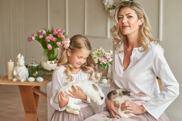 mom and daughter with bunnies at the easter table - Фото, зображення