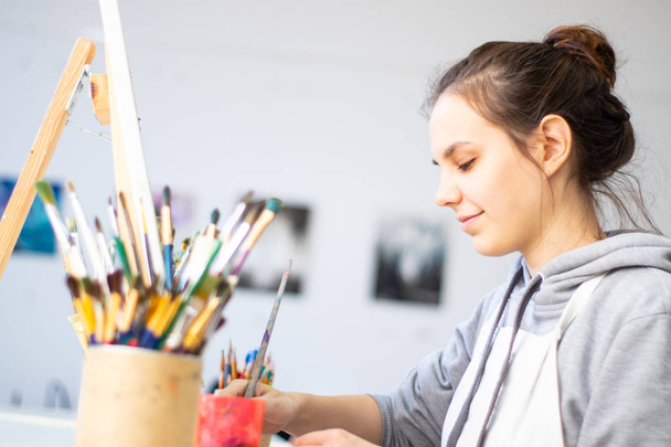 Girl artist paints a picture on canvas - Zdjęcie, obraz