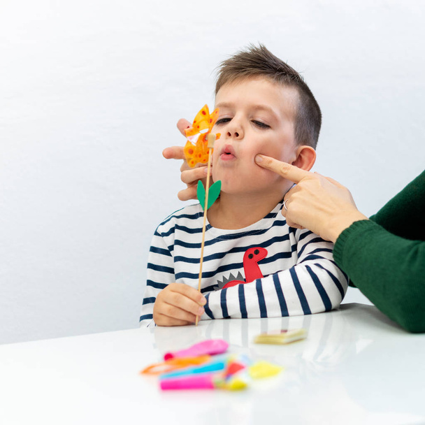 Young boy in speech therapy office. Preschooler exercising correct pronunciation with speech therapist.  - Foto, Bild
