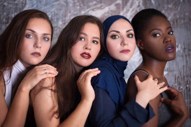 Portret van vier meisjes met verschillende huidskleur en nationaliteit in de studio. - Foto, afbeelding