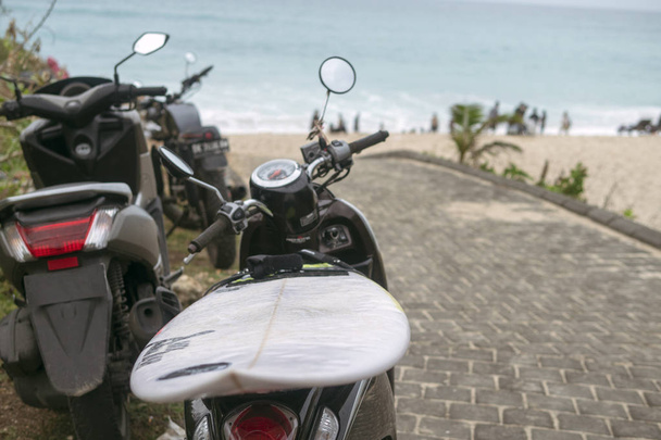 Skootterit, surffilaudalla varustetut moottoripyörät meren taustalla
 - Valokuva, kuva