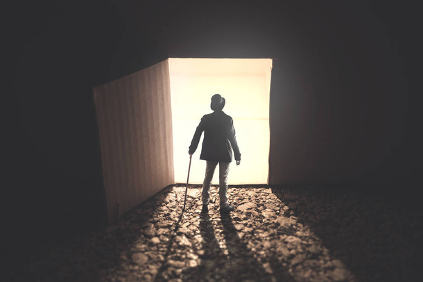 uomo in piedi di fronte a una porta aperta alleggerita al buio
 - Foto, immagini