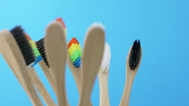 Kleurrijke tandenborstels in spinnen tandenborstel beker op blauwe achtergrond - Video