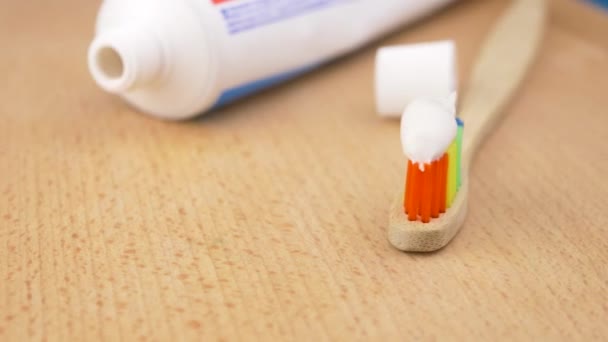 Zahnbürste mit Zahnpasta auf einem hölzernen Hintergrund - Filmmaterial, Video