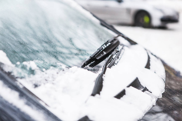 Snow covered dark car. Parked vehicle close up. The machine is covered with hoarfrost. Winter snowfall. - Photo, Image