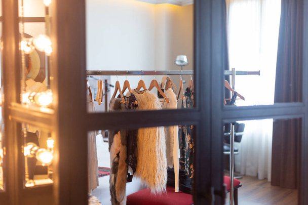 intérieur de la loge d'une actrice, avec un miroir avec ampoule et un étagère avec des vêtements
 - Photo, image