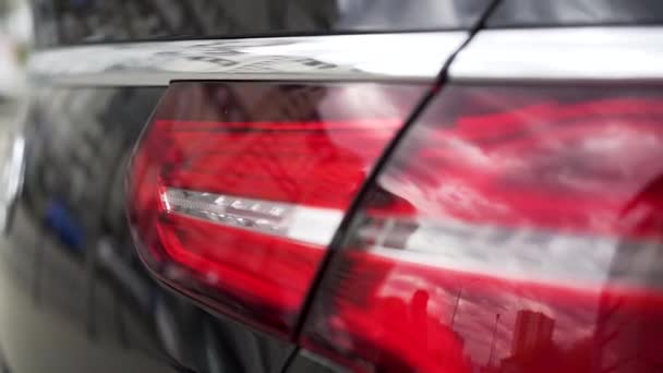 Close up de luzes traseiras vermelhas, detalhe de moderno, luxo, SUV preto. Estoque. Luzes de quebra de carro preto, conceito de iluminação automotiva
. - Filmagem, Vídeo