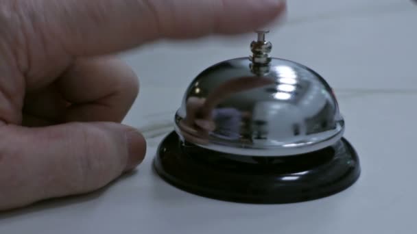 Pessoa toca uma campainha na recepção do hotel
 - Filmagem, Vídeo