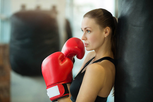 beautiful young girl engaged in training in the gym with boxing gloves - Foto, imagen