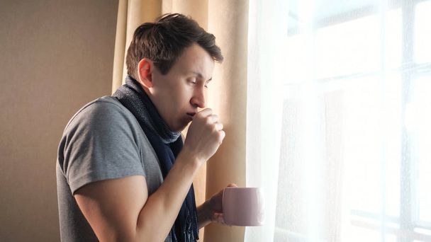 Beteg férfi bögre köhögés közelében ablak - Fotó, kép