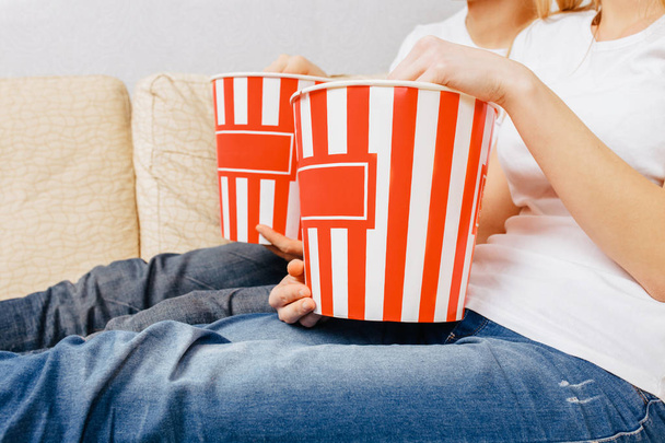 hands hold popcorn, homely atmosphere - Φωτογραφία, εικόνα
