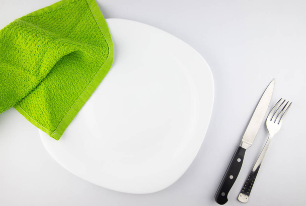 Вид сверху пустой белой тарелки с вилкой и ножом
 - Фото, изображение