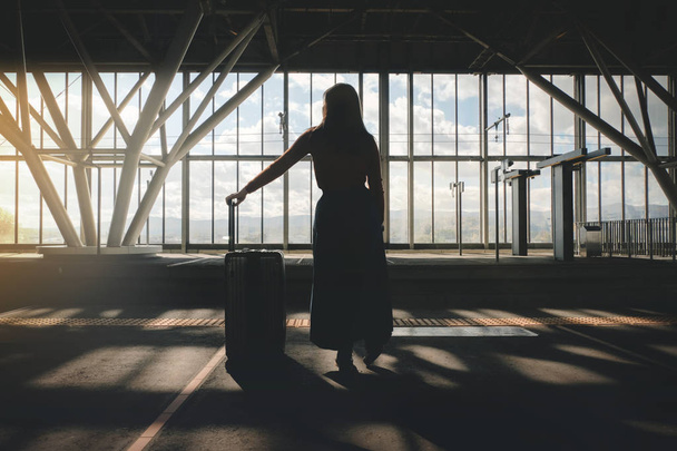 Seyahat kavramı. Tren istasyonunda platformda bavul ile genç bir kadın bekliyor. Tren ile seyahat - Fotoğraf, Görsel