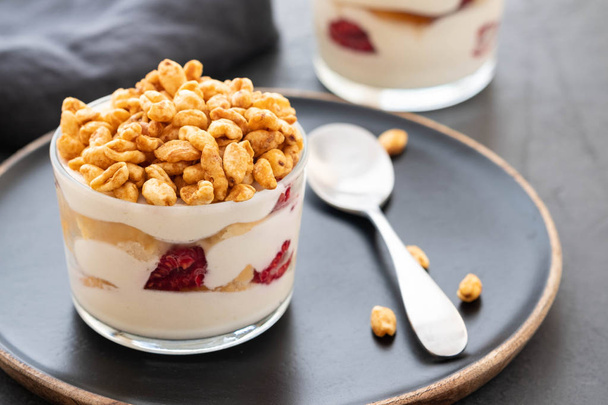 Fresh yoghurt with rasberry in clear glass. Raspberries in white bowl. Healthy morning breakfast. - 写真・画像