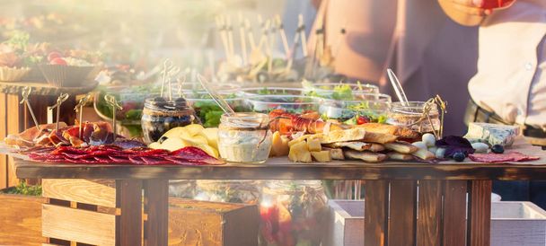 Table de banquet traiteur joliment décorée avec différentes collations alimentaires et apéritifs avec sandwich, lors d'un événement de fête d'anniversaire de Noël ou d'une célébration de mariage
 - Photo, image