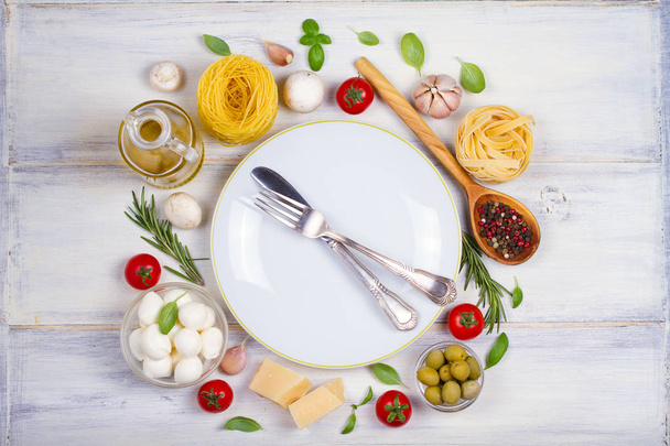 italienisches Essen oder Zutaten mit frischem Gemüse, Nudeln, Käse-Mozzarella und Parmesan, Gewürzen. gesunde Ernährung Hintergrund. über Kopf, horizontal - Foto, Bild