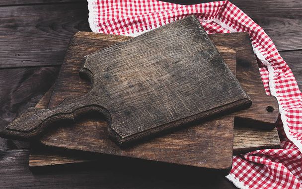 pila di vecchi taglieri da cucina in legno e un asciugamano rosso su un tavolo marrone, la vista dall'alto
 - Foto, immagini