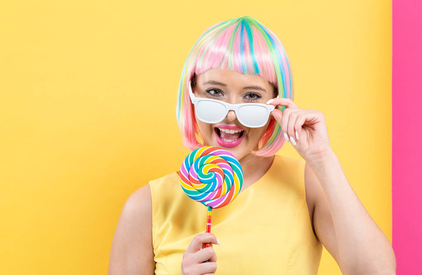 Woman in a colorful wig with a lollipop - Fotoğraf, Görsel