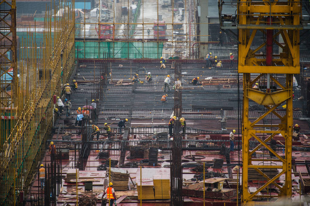 Китайские рабочие трудятся на строительной площадке самого длинного в мире морского моста, моста Гонконг-Чжухай-Макао, в городе Чжухай, провинция Гуандун на юге Китая, 21 мая 2017 года
 - Фото, изображение
