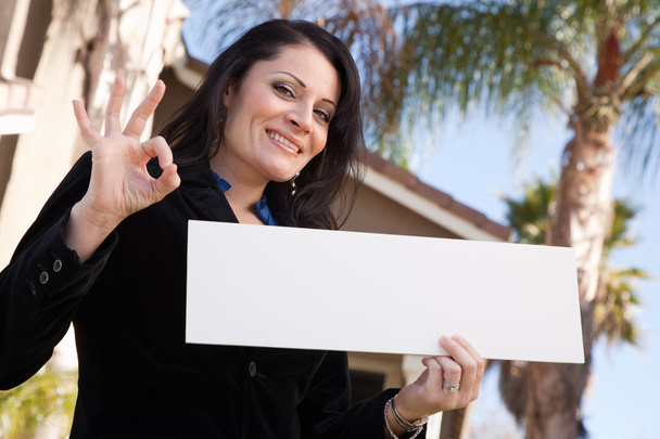 Mujer hispana feliz sostiene signo en blanco
 - Foto, imagen