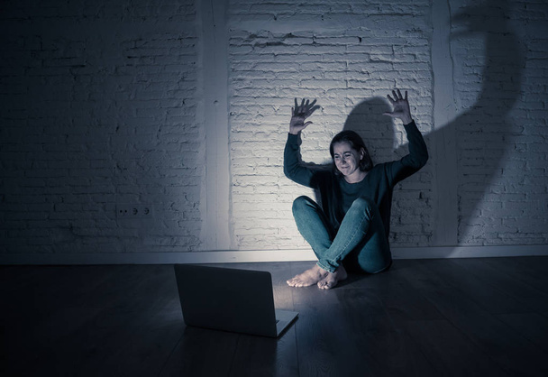 Sad and scared female Young woman with computer laptop suffering cyberbullying and harassment being online abused by stalker or gossip feeling desperate and humiliated in cyber bullying concept. - Photo, Image