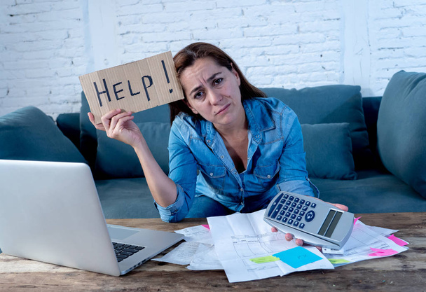 Portrait of young single mother business woman feeling stressed holding Help sign message and calculating finances with laptop and calculator in Paying off debts and Domestic bills and financial problems concept. - Foto, Imagen