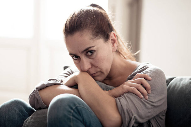 Young attractive latin woman lying at home living room couch feeling sad tired and worried suffering Depression in Mental health, Problems Emotional pain and Broken heart concept. - Photo, Image