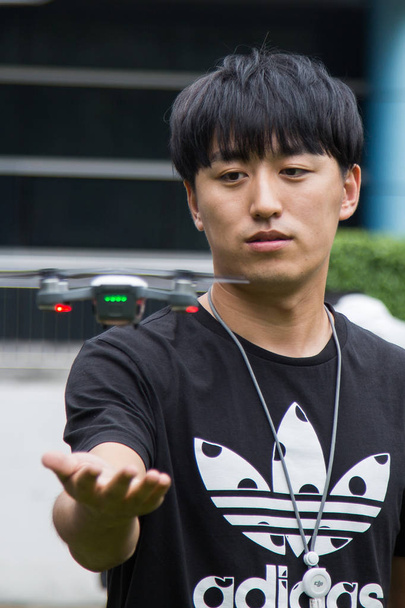 A Chinese man shows DJI's new Spark drone, or UAV (unmanned aerial vehicle), during a demonstration flight in Shenzhen city, south China's Guangdong province, 25 May 2017 - Foto, afbeelding