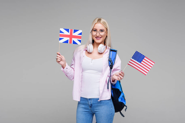 Education, foreign language translator, english, student - smiling blond woman in headphones holding American and British flags. Distance learning - Foto, Bild