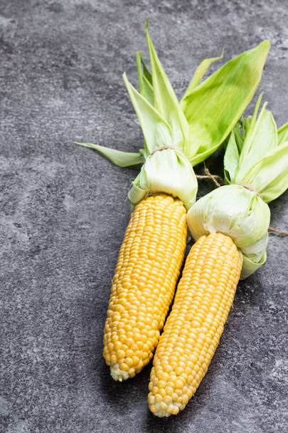 Raw corn  on cobs on grey table  - Фото, зображення
