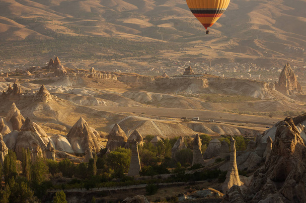 Beautiful landscape of Cappadocia valley with hot air balloons in background at sunrise - 写真・画像