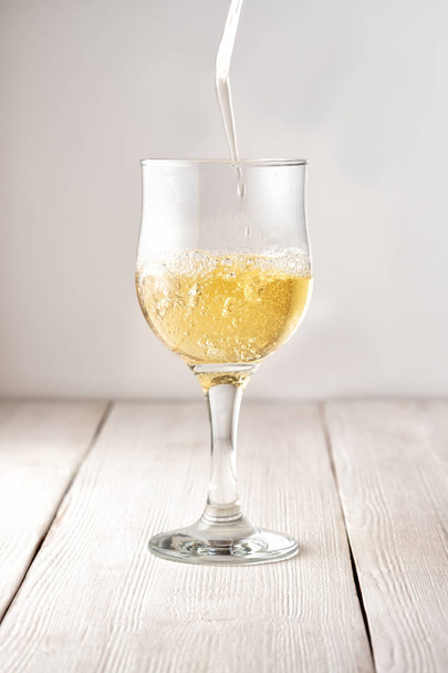 a glass of white wine over a white wooden background - Φωτογραφία, εικόνα