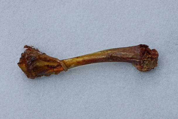 brown fried chicken bone lying on white snow - Photo, Image